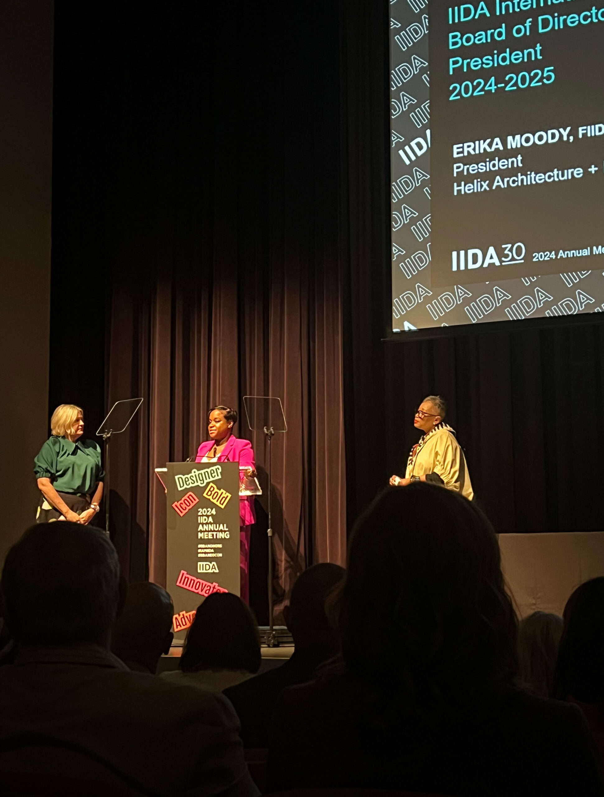 Three women on stage during a conference